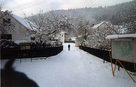 melcovna v zim. Budova za cedul s mapou je hospoda, ale maj tam oteveno jen od tvrtka do nedle a jet a od dvancti hodin.